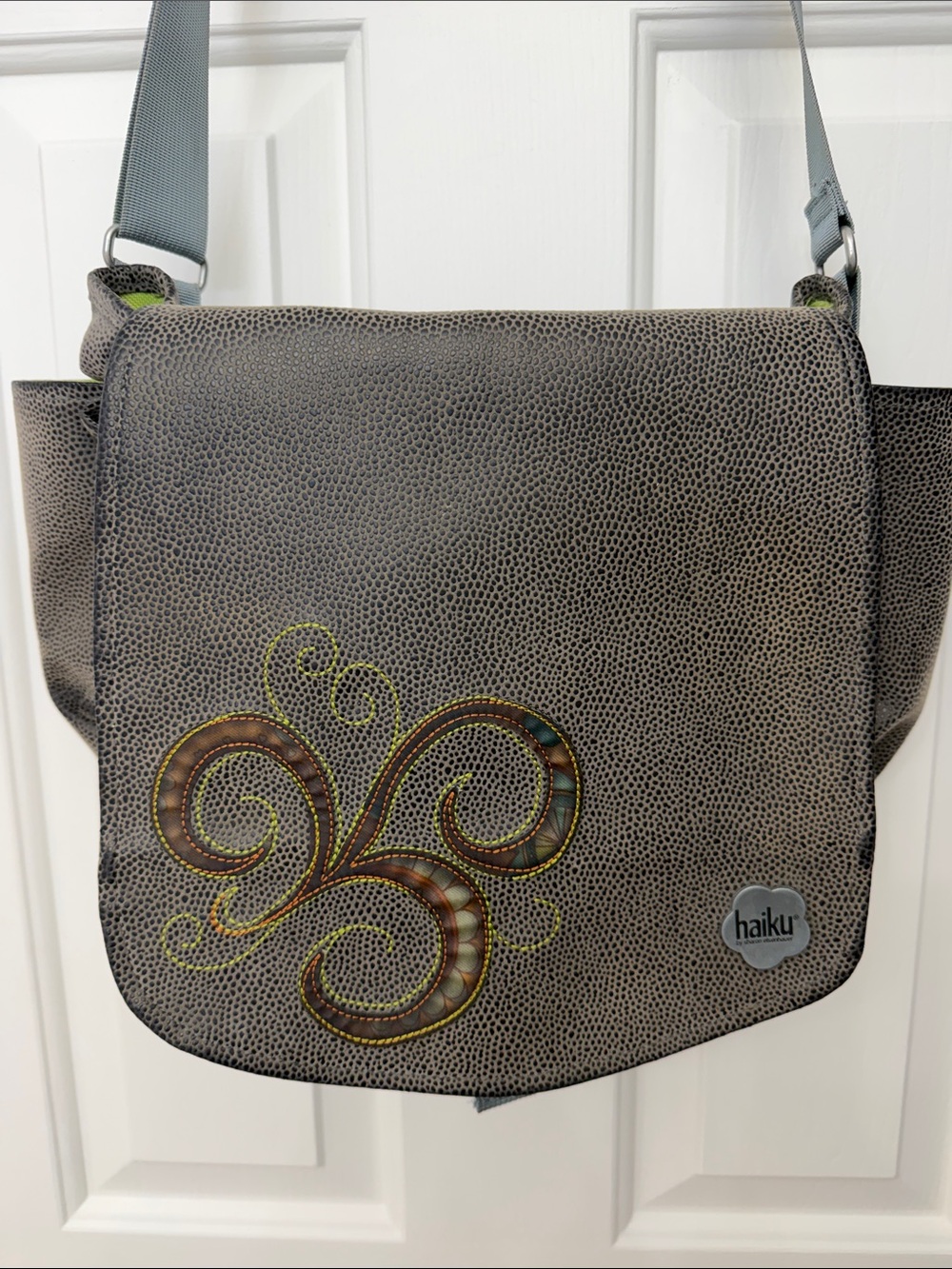 Haiku Gray Pebbled Messenger Bag with Decorative Swirl Accent